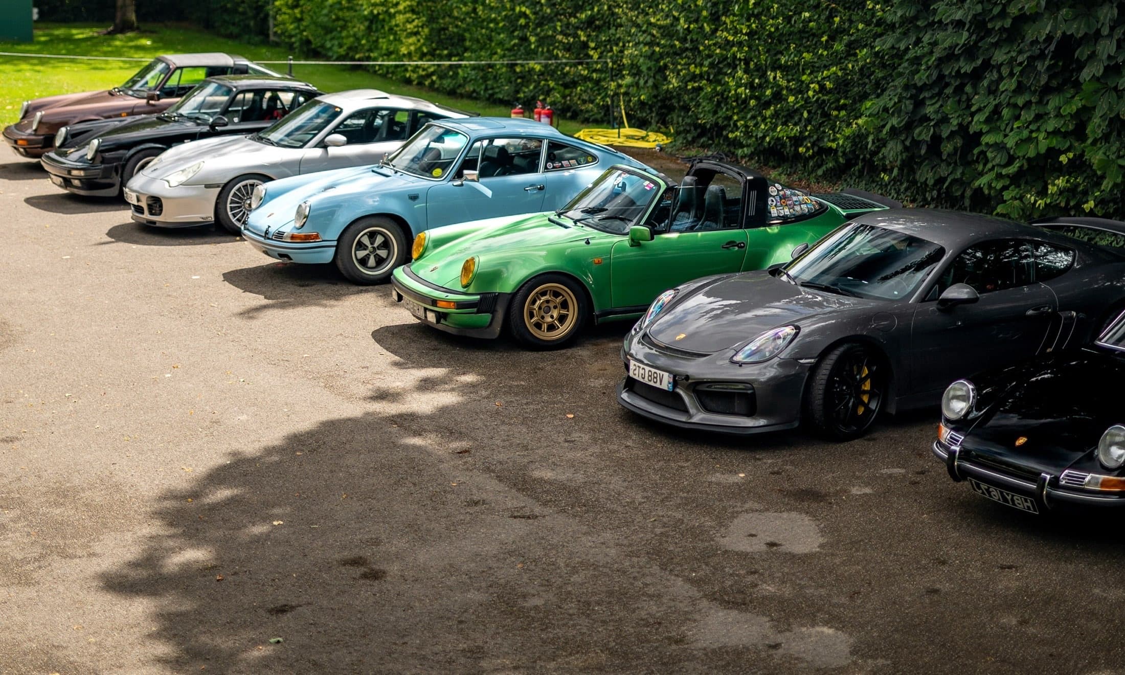 Crowd walking through rows of cars at an outdoor automotive event